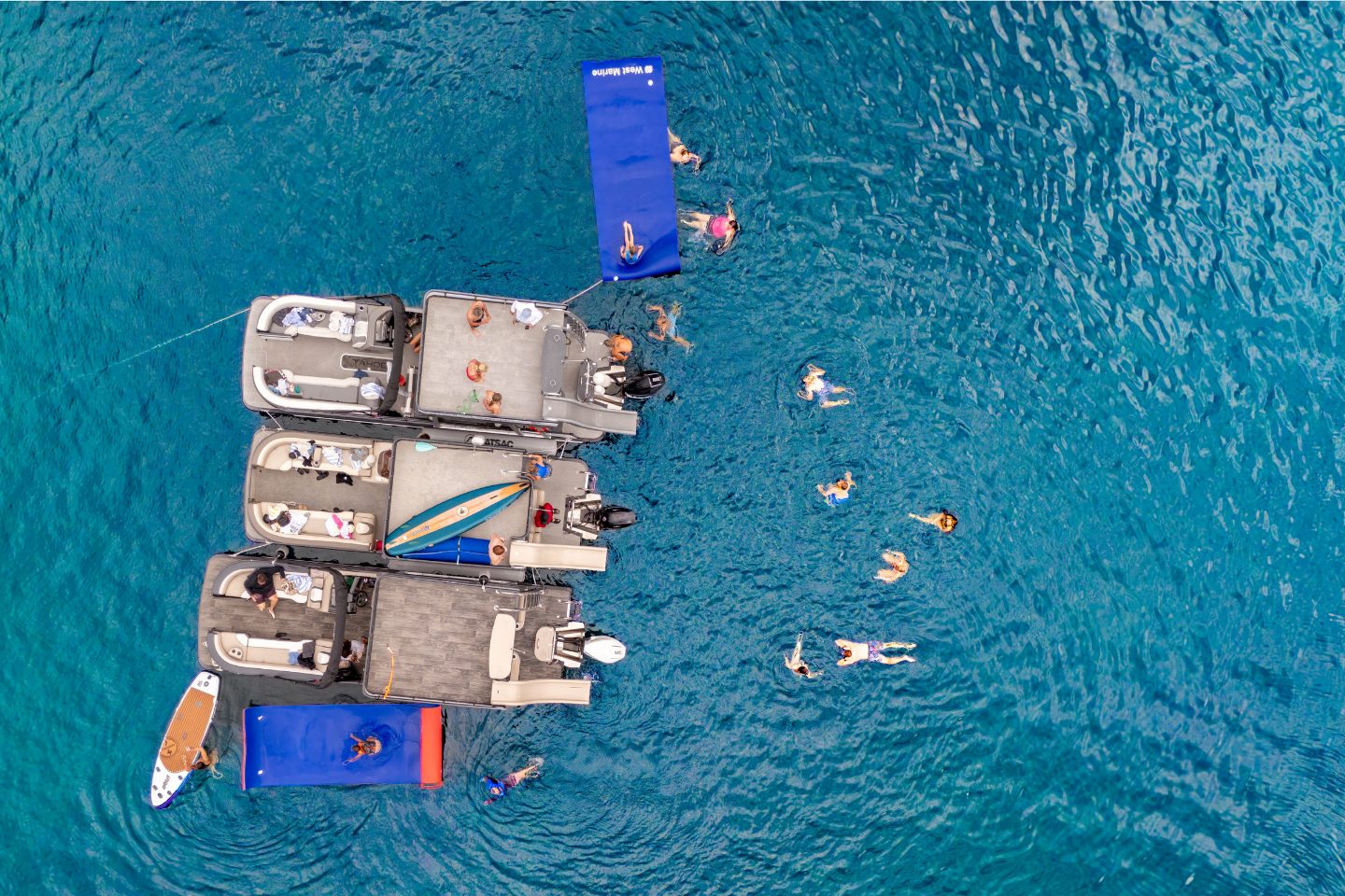 south-lake-tahoe-boat-rental-gallery (7) overhead image of three lake tahoe pontoon boats with people swimming